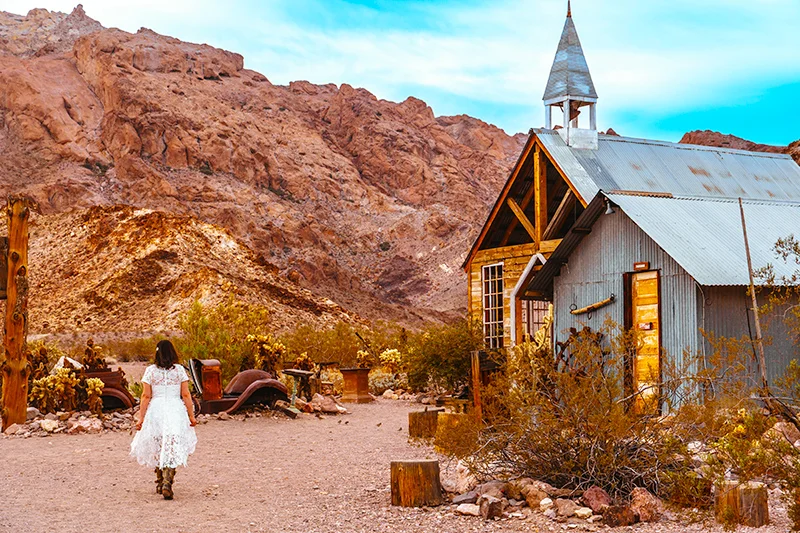 Bride walking in front of the chapel at Nelson Ghost Town