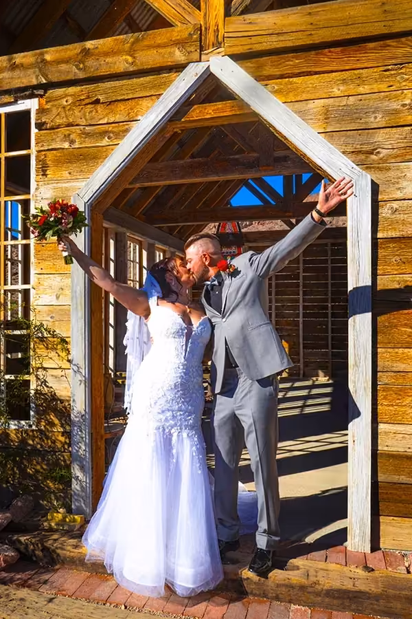 A couple shares their first kiss as newlyweds in front of the chapel at Nelson Ghost Town in Eldorado Canyon