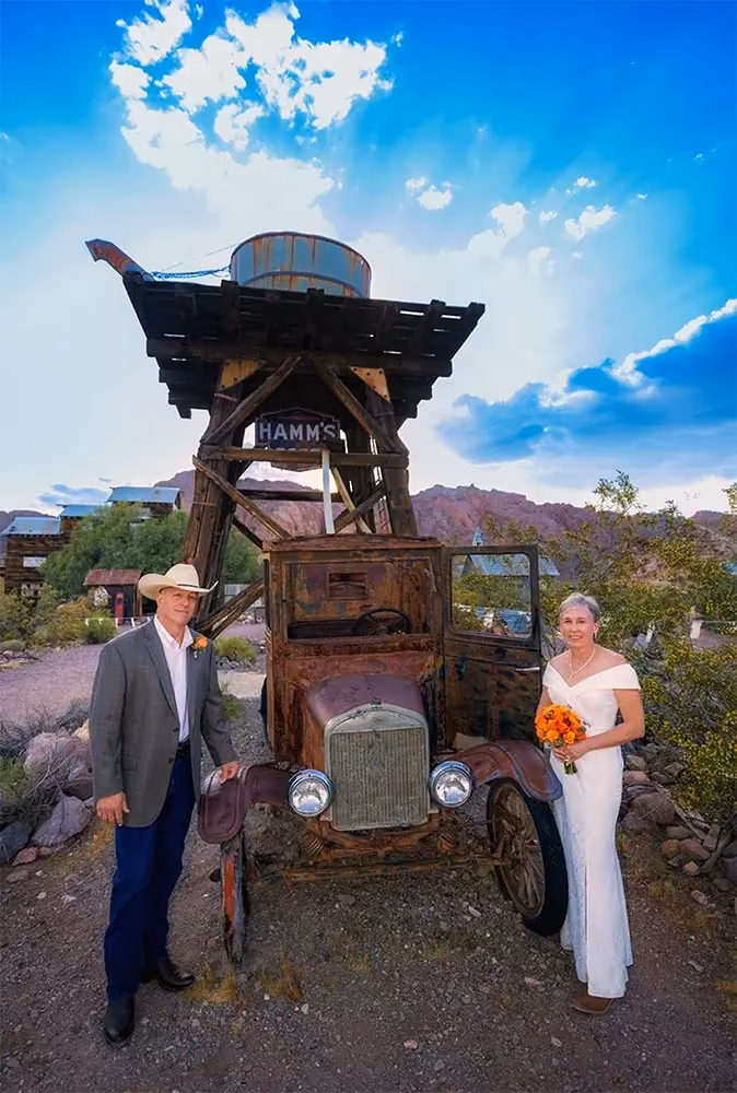 A wedding couple poses beside the historic water tower at Nelson Ghost Town, one of the gold-era landmarks in Eldorado Canyon